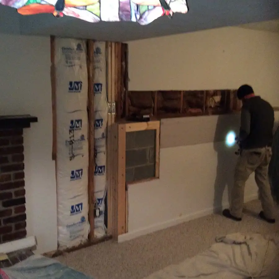 Restoration technician inspecting water damage in Baker